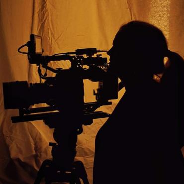 Maribeth Romslo, a woman filmmaker, working with a cinema camera.