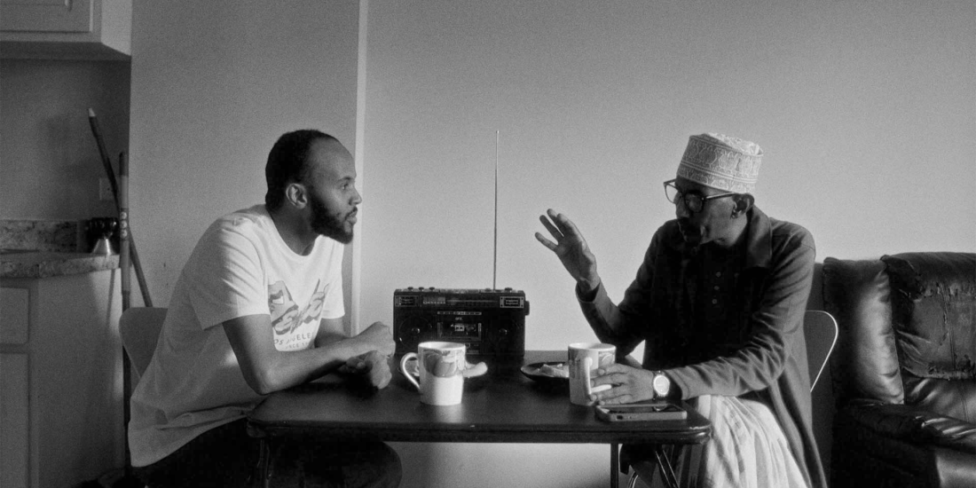 Two men seated at a table (still from Balwo)