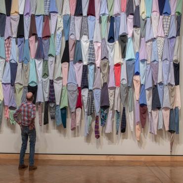 An installation of fabric shirts in a gallery.