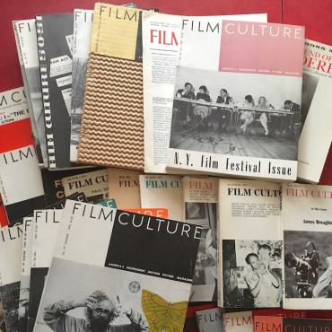 Many issues of Film Culture magazine laid out on a table.