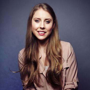 A portrait of Natalie Gee, smiling at the camera.