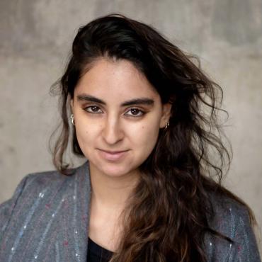 Karina Dandashi, an Arab-American filmmaker wearing a blazer, posing for the camera.