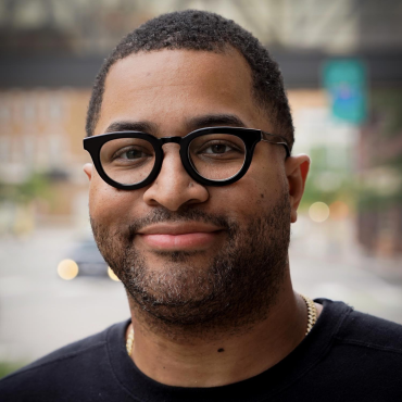 Tommy Franklin, 40-year-old Black man with short cropped hair, wearing black shirt and black glasses