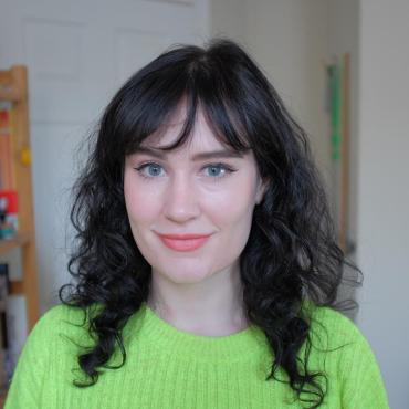 Maggie Brennan, a thirty-something white woman, smiling at the camera.