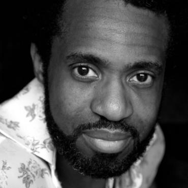 Siji Awoyinka, a middle-aged Black man smiling at the camera.