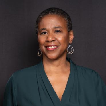 A headshot of Leslie Fields-Cruz smiling